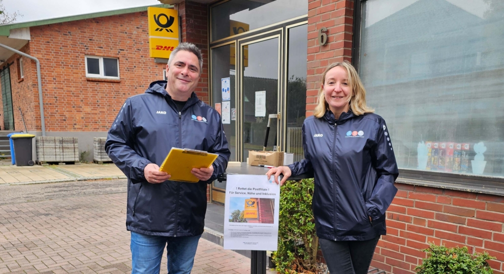 Zwei Mitglieder der ABS an einem Stehtisch vor der Postfiliale.